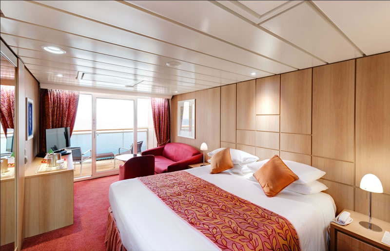 a bedroom with a bed and a couch in a room with a balcony